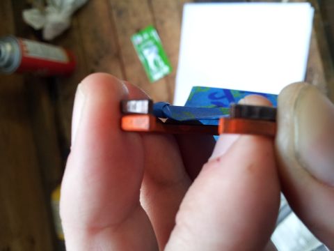 2002 Chrysler 300M - A person is holding a small automotive part, possibly a sensor or connector, with blue tape applied.