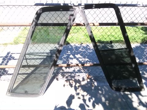 1992 Ford Bronco - Two car doors with metal frames are displayed outdoors against a chain-link fence.
