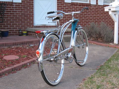 1994 Ford Bronco - This vintage bicycle features extensive chrome detailing, a distinctive blue frame, and classic white-walled tires, seen from a rear perspe…
