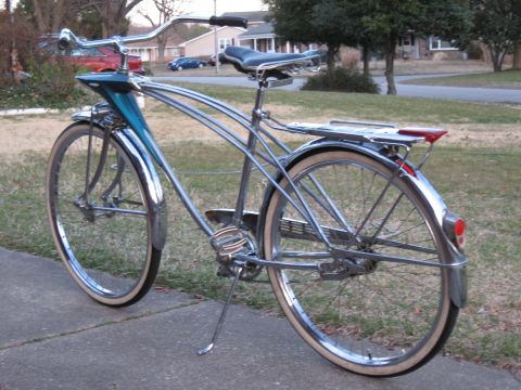 1994 Ford Bronco - A vintage bicycle with chrome frame, teal accents, and whitewall tires is parked on a sidewalk.