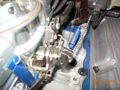 1979 Ford F-150 - Detail of engine cruise control linkage with a blue spring and beaded chain visible.