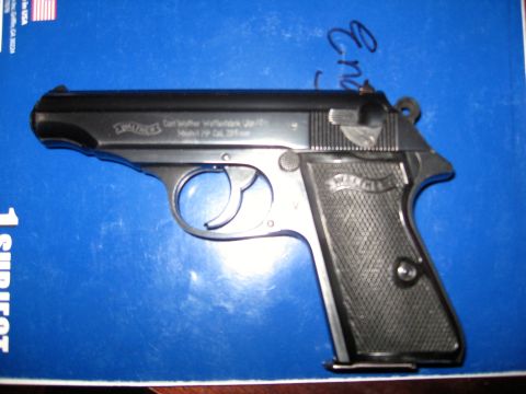 1992 Ford Mustang - A black Walther PP pistol is displayed on a blue background, with visible text on the slide and grip.