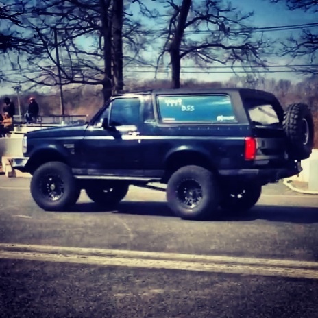 1995 Ford Bronco - This dark blue 1995 Ford Bronco features aftermarket wheels and a spare tire mounted on the rear tailgate.