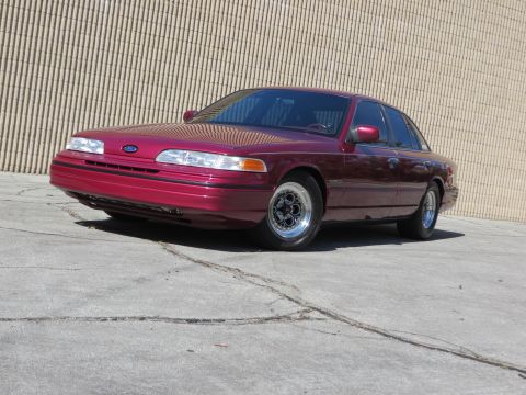 1992 Ford Crown Victoria - Maroon 1992 Ford Crown Victoria with aftermarket wheels sits outside.