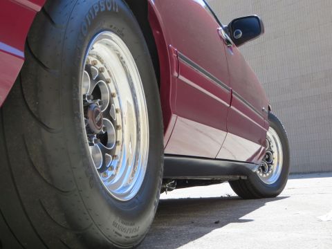 1992 Ford Crown Victoria - Close-up side view of a red car Weld Magnum III wheels and performance tires.