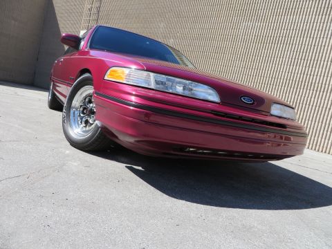 1992 Ford Crown Victoria - Front three-quarter view of a maroon 1992 Ford Crown Victoria with custom wheels.