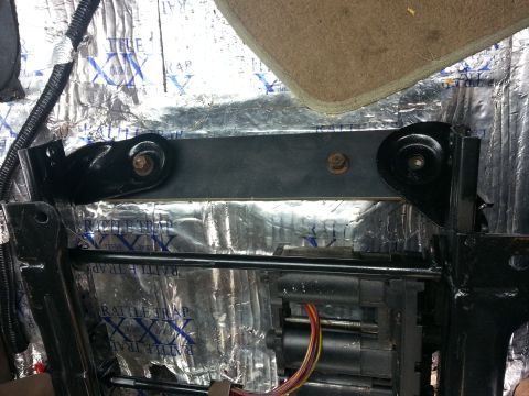 1994 Ford Bronco - Close-up of vehicle seat mounting hardware and sound dampening insulation.