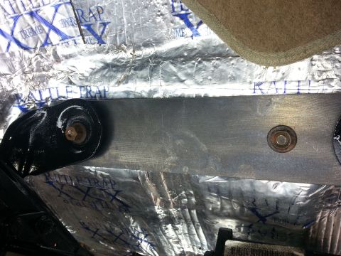 1994 Ford Bronco - This photo shows sound dampening material and a seat mounting bracket inside a vehicle.
