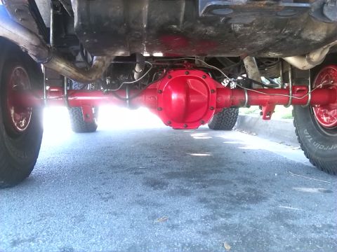 1992 Ford Bronco - Underside view of a vehicle's rear axle and suspension system, painted red.
