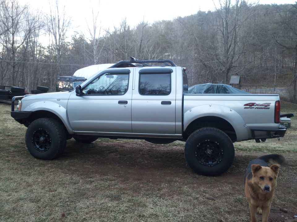 Silver 2003 Nissan Frontier pickup truck, side view, with off-road tires and custom bumper