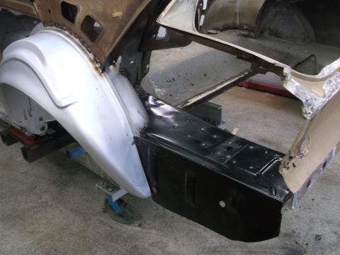 1967 Ford Mustang - Close-up of a vehicle's rear quarter panel and wheel well area during restoration.