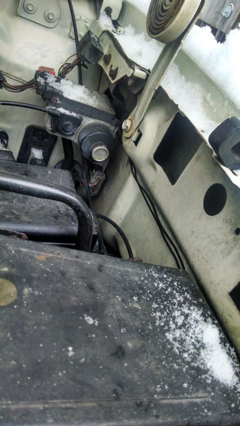 1995 Ford Bronco - Close-up view of engine bay components with snow accumulation.