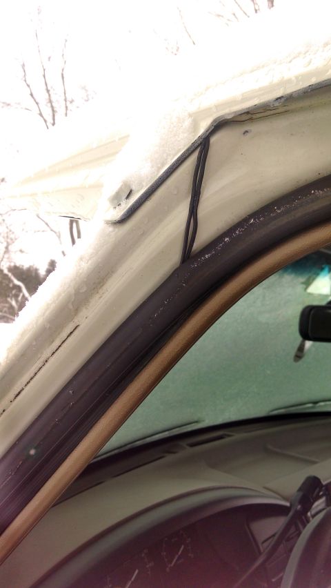 1995 Ford Bronco - Snow covers the exterior of the vehicle, visible through the frosted windshield and around the interior trim.
