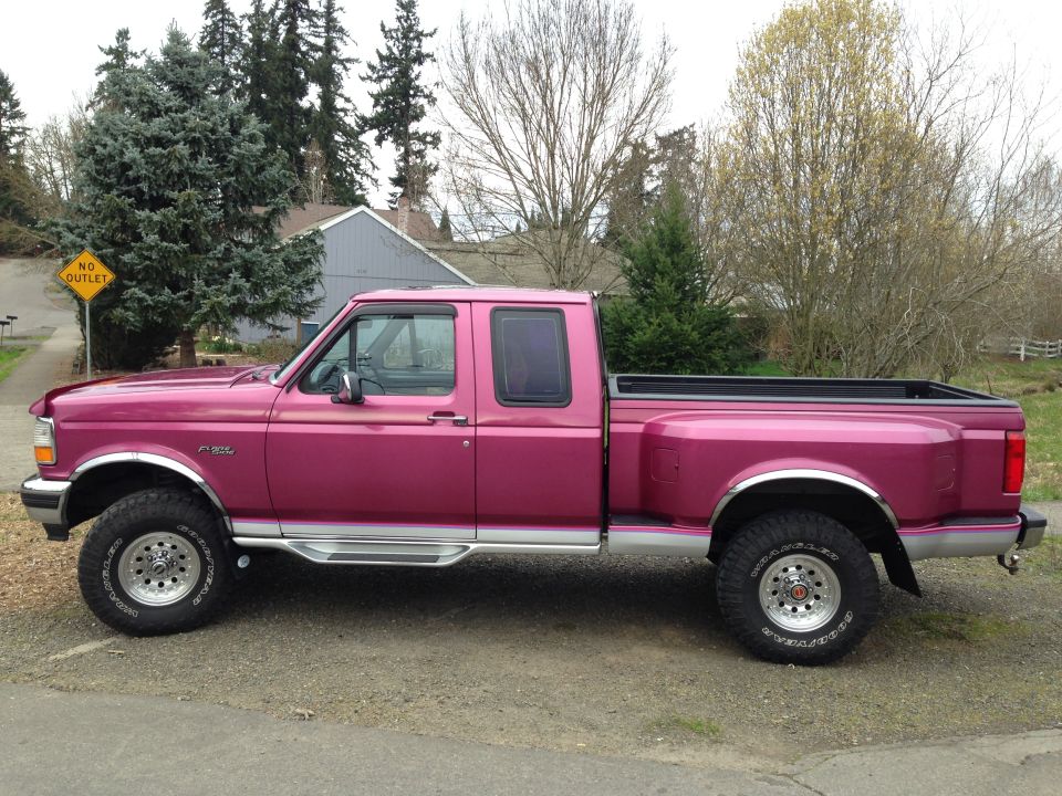 Pink Ford F-350 Super Duty pickup truck, side view, with chrome trim and aftermarket wheels