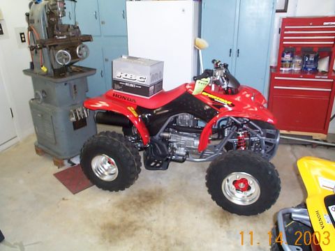 1978 Ford Bronco - A red Honda ATV is parked in a garage next to a yellow ATV and a large milling machine.