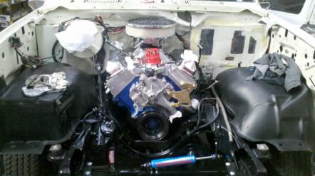 1982 Ford Bronco - The engine bay of a vehicle, a V8 engine and the Supermotors.net logo in the lower right corner.