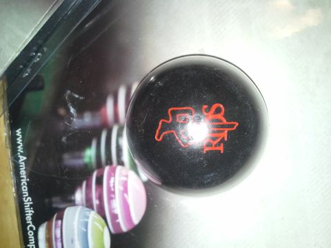1968 Ford Bronco - A black shift knob with a red RKS logo is shown, with other shift knobs and a website visible in the background.