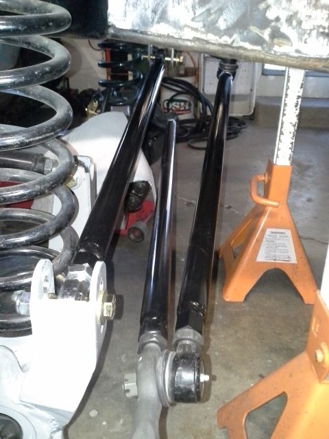 1968 Ford Bronco - Suspension parts, likely for a 4x4, are shown on jack stands in a workshop setting.
