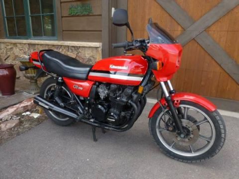 2008 Ford Crown Victoria - A red Kawasaki GPz motorcycle is parked on a paved surface in front of a wooden structure.