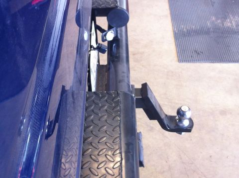 1982 Ford Bronco - The rear of a blue vehicle shows a trailer hitch and bumper detail.