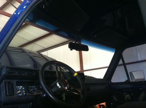 1982 Ford Bronco - The interior of a blue 1982 Ford Bronco is visible, the dashboard and steering wheel.
