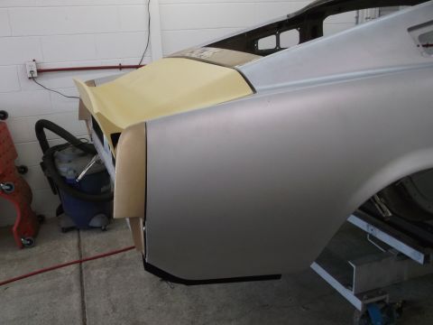 1967 Ford Mustang - Rear section of a car undergoing restoration, showing unfinished bodywork and primer application.