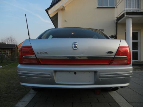 1999 Ford Fairlane - Rear view of a silver sedan with a 'Fairlane' badge and a red accent strip across the trunk.