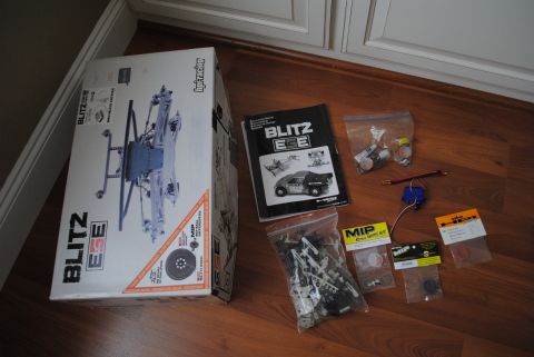 1986 Ford Bronco - RC car parts and manual laid out on a wooden floor.