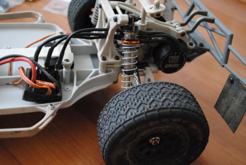 1986 Ford Bronco - Close-up view of a remote control car's chassis, highlighting the suspension, motor, and electronic components.