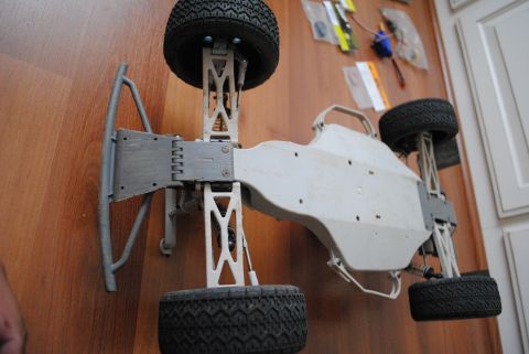 1986 Ford Bronco - The underside of a remote control car chassis is shown, with its suspension and tires visible.