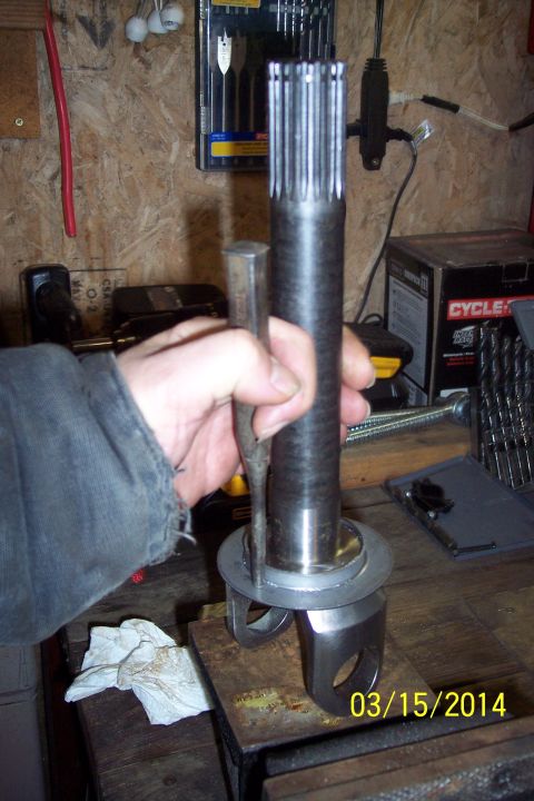 1973 Ford F-250 - A splined shaft and yoke assembly is held while being worked on with a chisel.