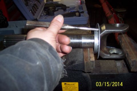 1973 Ford F-250 - A close-up of a vehicle axle component being worked on in a vise, with tools in the background.