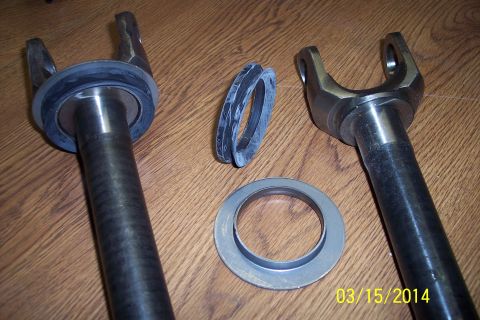 1973 Ford F-250 - Front knuckle-joint components, including yokes and seals, are laid out on a wooden surface.