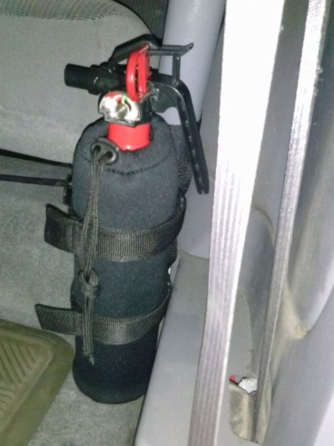 1995 Ford Bronco - A fire extinguisher is secured inside a vehicle's cabin.