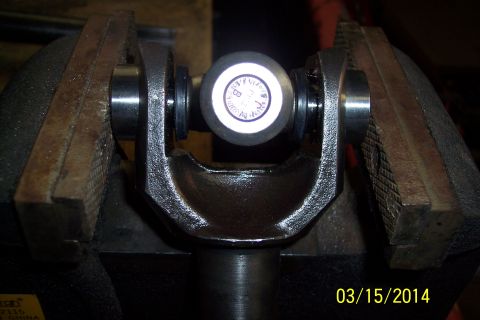 1973 Ford F-250 - A close-up view of a universal joint secured in a vise, showing a marked center cap.