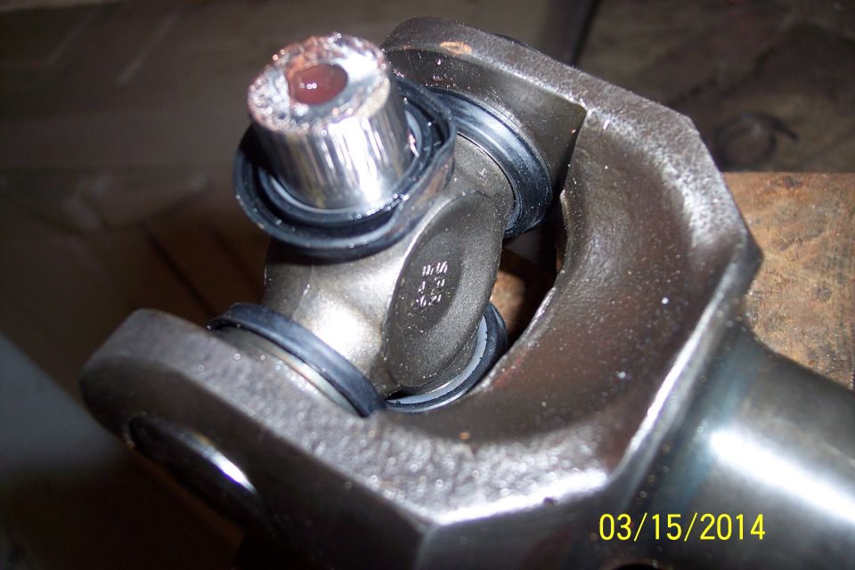 Close-up of a driveshaft U-joint with visible wear and grease