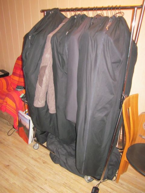 1991 Ford Crown Victoria - A collection of clothes are stored in protective bags on a metal rack.