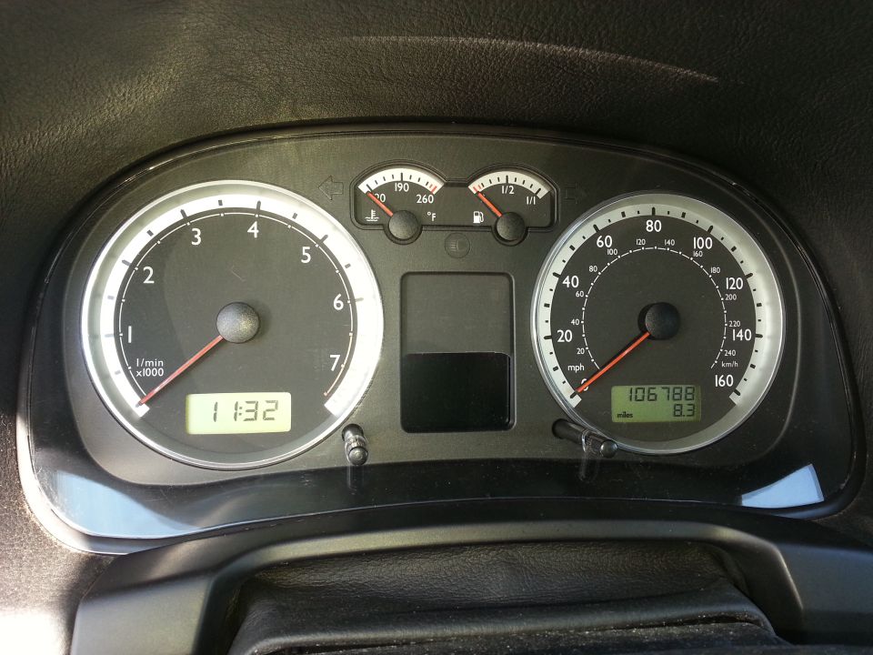 Car dashboard with speedometer, tachometer, fuel gauge, and temperature gauge. Odometer shows 106788 miles