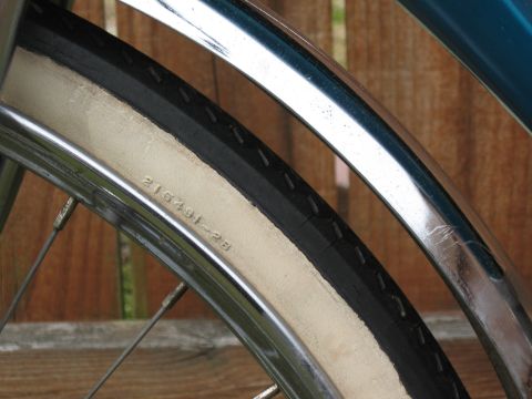 1994 Ford Bronco - A detail shot of a bicycle's white-walled tire and chrome fender shows some embossed text on the tire's sidewall.