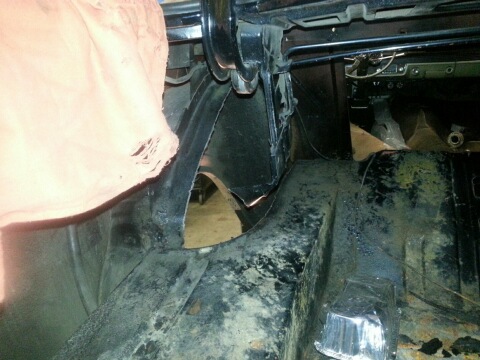 1966 Mercury Comet - The interior of a car shows significant rust and damage, with a torn piece of fabric in the foreground.