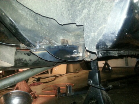 1966 Mercury Comet - The underside of a vehicle is shown, with repairs being made to the frame and body panels.