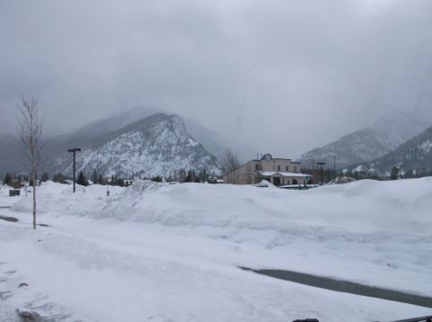 2009 Kenworth T800 - A winter scene with snow-covered mountains and a building, under a heavily overcast sky.