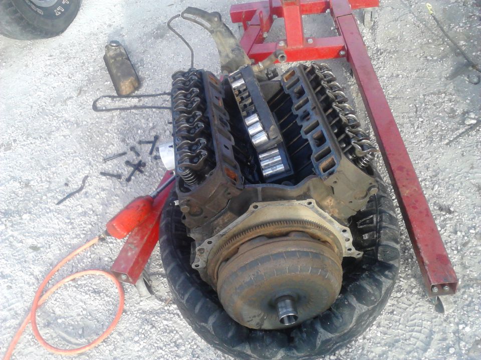 DAY 2:

Pulled the old seized motor out. Since the motor was seized, I couldn't get to the torque converter nuts and had to pull the torque converter with the engine. 

Also I started tearing down the engine to decide if its salvageable or not. took the heads off and the heads looked good. cylinders looked good. pulled the pan off and found a lot of metal pieces that im assuming to be bearing material. took the timing chain off and the cam spins easily but the crank can barley turn with a breaker bar. assuming a rod bearing spun but wont know till I tear it down more.