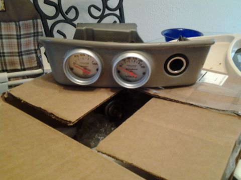 2004 Ford Crown Victoria - Gauge cluster housing with temperature and voltage gauges, sitting on cardboard boxes.