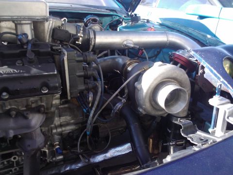 1995 Ford Probe - Close-up of a modified engine bay a large turbocharger and custom piping.
