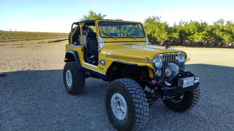 1985 Jeep CJ7 - This yellow Jeep CJ is equipped with off-road tires and a front-mounted winch.