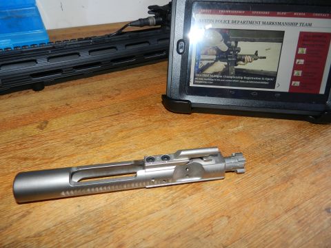 1996 Ford Bronco - A bolt carrier group and AR-15 handguard are displayed on a wooden surface, with a tablet showing a website for the Austin Police Departmen…