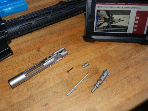 1996 Ford Bronco - Rifle parts laid out on a table next to a tablet showing a marksmanship team website.