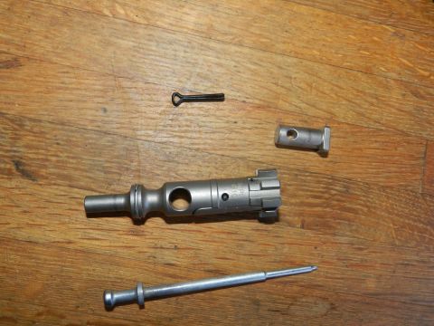 1996 Ford Bronco - Disassembled gun parts are laid out on a wooden surface, with a watermark indicating 'SUPERMOTORS'.