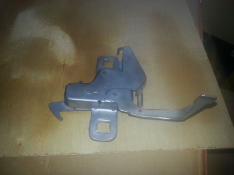 1994 Ford Bronco - A metal hood latch mechanism is shown against a light brown background.